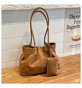 Detail of vintage brown suede tote bag with contrast stitching and small side pouch