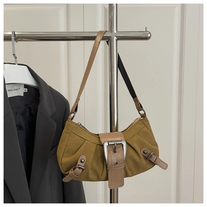 Detailed view of brown suede underarm bag with vintage metal buckle and silver studs