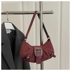 Detail of burgundy suede crescent bag showing the large vintage metal buckle and pleats
