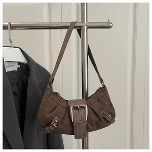 Detailed view of dark brown vintage dumpling bag with a large silver buckle and suede texture