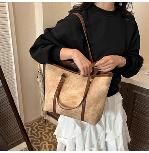 Detail of vintage marble texture tote bag with brown leather trim in home setting