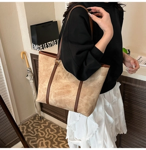 Dettaglio di una borsa tote grande a contrasto in camoscio beige e manici in pelle marrone