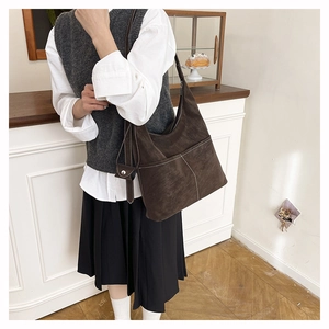 Detail of brown faux suede tote bag with contrast stitching and retro shoulder strap