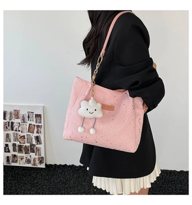 Detailed shot of pink star pattern tote bag featuring a plush cloud charm and metal chain strap