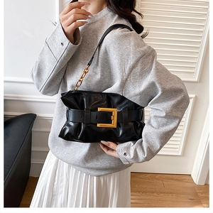 Détail du sac nuage noir plissé avec une grande boucle dorée et bandoulière chaîne