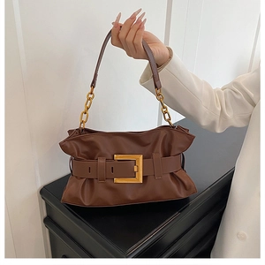 Détail d'un sac nuage plissé marron avec boucle dorée et bandoulière en chaîne