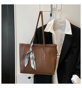 Brown tote bag with lychee grain texture and floral silk scarf detail on handle