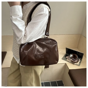 Dettaglio della borsa Boston in pelle PU marrone scuro lucida con finiture argento