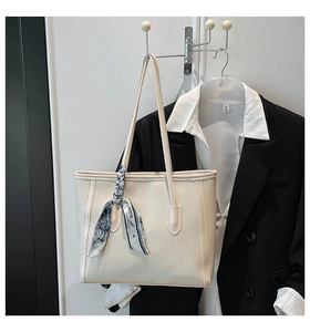 Close-up of cream leather tote bag with printed silk scarf detail for office fashion