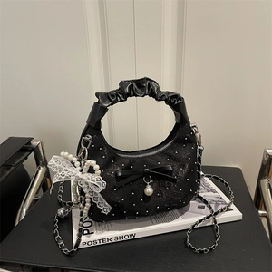Elegant black half-moon shoulder bag with pearl charms, ribbon bows, and a chain strap