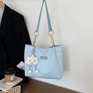 Light blue tote bag with silver star prints and a plush cloud charm on a chain strap