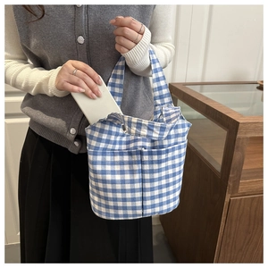 Détail du sac cabas en toile à carreaux bleus avec poche avant pour téléphone mobile