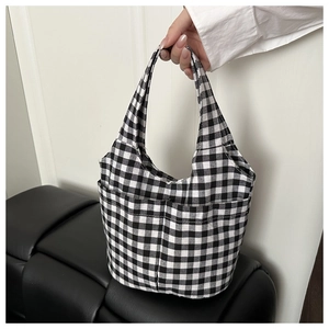 Detail of checkered canvas bucket bag with dual front pockets and thick woven texture