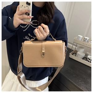 Detail van kaki lederen crossbodytas met brede riem en gouden metalen sluiting