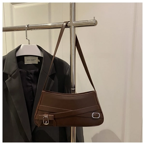 Close-up of vintage brown leather underarm bag featuring silver buckle and strap detail