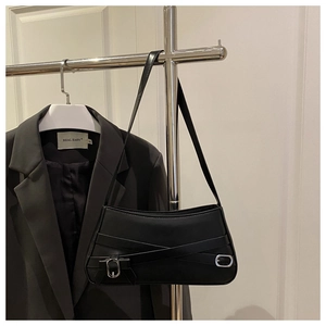 Detail of black leather underarm bag featuring silver buckles and side bow decoration