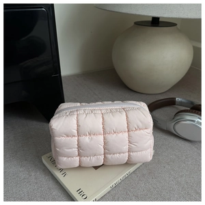 Close-up of pink quilted cosmetic bag with soft puffy texture and sleek zipper closure