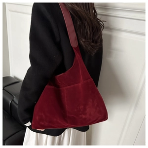 Detail of burgundy suede tote bag showing large capacity and soft texture in real-use scene