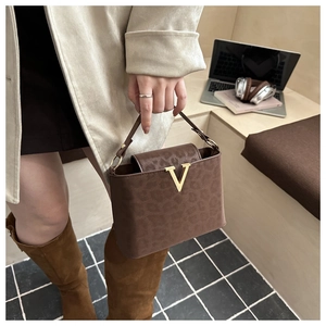 Detail of leopard print tote bag with gold V-buckle and textured faux suede finish