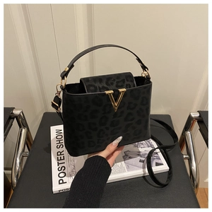 Detail of leopard print handbag featuring a gold V-shaped buckle and textured faux fur