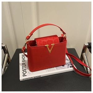 Detail of red leather handbag with gold V-clasp and stylish leopard print lining
