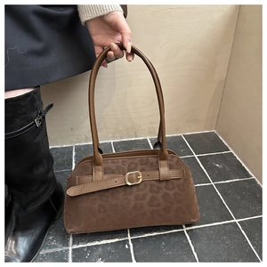 Detail of dark brown leopard print suede hobo bag with a gold buckle and leather strap