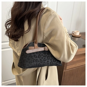 Detail of retro leopard print handbag with brown leather straps worn by model