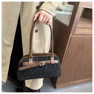Detail of leopard print suede bag with brown leather trim and golden buckle detail