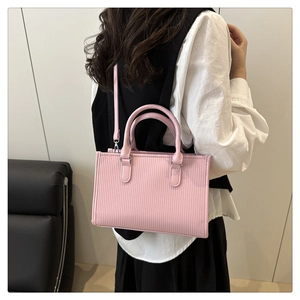 Pink tote bag with ripple texture leather shown from a side-view on a model