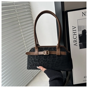 Detailed view of vintage faux suede shoulder bag with leopard pattern and brown leather handles