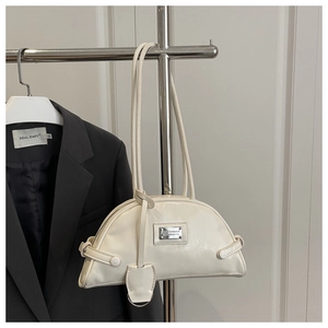 Detail of cream white faux leather bowling bag with metallic logo and top handles