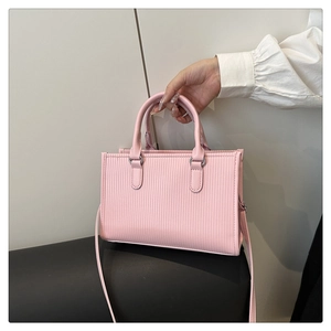 Detail of pink square handbag with vertical striped embossing and silver hardware accents