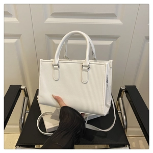 Detail of white rectangle tote bag showing vertical ribbed texture and rounded handles