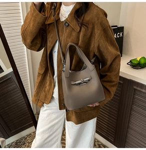 Détail du sac seau en cuir grainé taupe avec fermoir tournant en métal et bandoulière fine