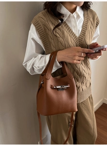 Vue détaillée d'un sac seau en cuir marron avec un fermoir en métal argenté et une bandoulière