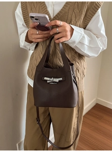 Détail du sac seau en cuir marron foncé à motif litchi avec fermoir tournant en métal