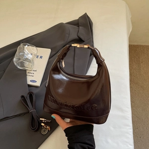 Vintage dark brown leather pillow bag with embossed lettering and gold hardware