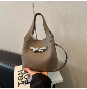 Détail du sac seau en cuir grainé gris avec fermoir métallique argenté et anse