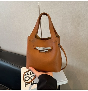 Détail du sac seau en cuir litchi marron caramel avec fermoir rotatif en métal argenté