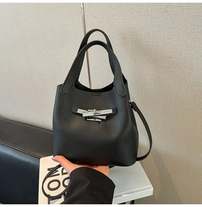 Détail du sac seau noir en cuir grainé avec boucle métallique argentée élégante et chic