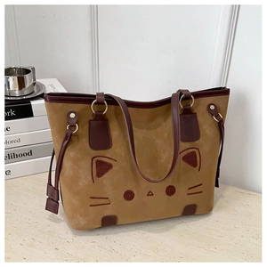 Détail du motif chat brodé sur un grand sac cabas en daim marron avec anses en cuir