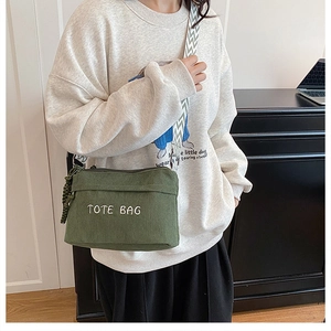 Détail du sac cabas en velours côtelé vert foncé avec broderie et sangle texturée