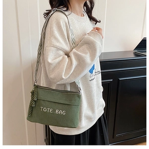 Detail view of army green corduroy tote bag with TOTE BAG embroidery and wave strap