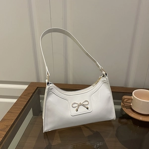 White patent leather underarm bag with gold bow detail and crescent moon shape