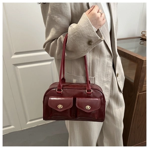 Detail of vintage dark red oil wax leather shoulder bag with gold metal twist locks