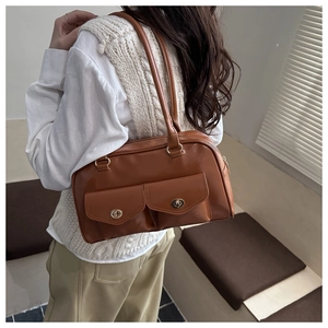 Brown faux leather bowling bag with vintage metal locks shown on model shoulder