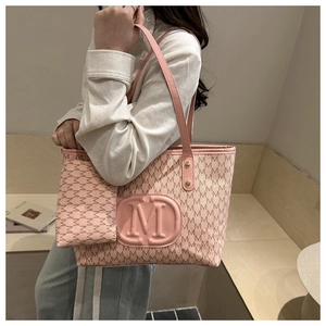 Set borsa tote rosa con motivo monogramma e pochette coordinata in contesto lifestyle