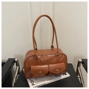 Detail of vintage brown leather handbag featuring gold metallic twist locks and glossy finish