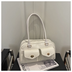 Detail of off-white shoulder bag with dual front pockets and golden twist-lock closures