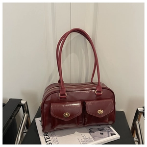 Detailed close-up of dark red vintage faux leather handbag with golden twist-lock pockets